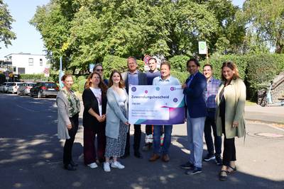 Die Stadt Königswinter freut sich zusammen mit Vertreterinnen und Vertretern von go.Rheinland, der Bezirksregierung Köln und der Baufirma Wurzel über die Förderungen und den Start der Maßnahmen an der Rheinuferstraße. © Stadt Königswinter Gruppenbild am Rheinufer vor der Haltestelle in Niederdollendorf