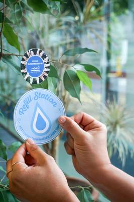 Aufkleber wird an Fenster geklebt