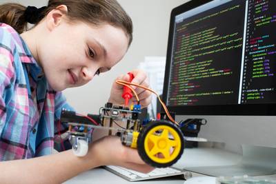 Mädchen baut und programmiert einem Roboter