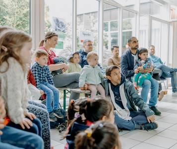Väter und Kinder sitzen im Rathaus und nehmen am Familienprogramm teil