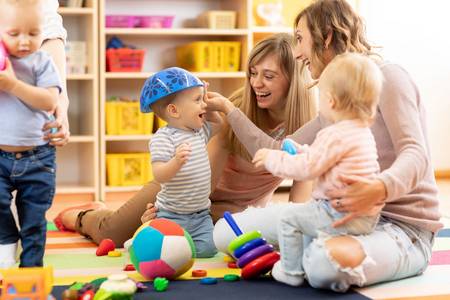 Kinder spielen mit Erzieherinnen