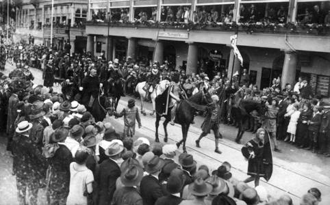 schwarz-Weiß-Foto eines Festzuges mit Pferden