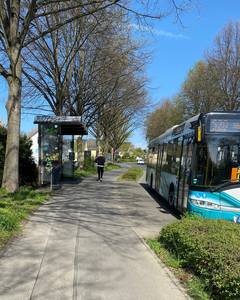 Weg zur Bushaltestelle, Bild mit Wartehäuschen und Bus