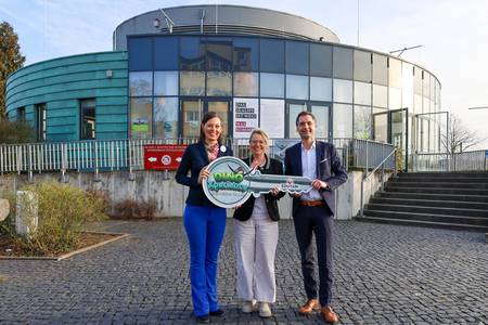 Janine Jaensch (li.), CEO der EDUTAIN AG, übernahm den symbolischen Schlüssel für die künftige Erlebniswelt DinoXperience – Expedition Urzeit von Bürgermeisterin Heike Jüngling und dem Landtagsabgeordneten Jonathan Grunwald. © Stadt Königswinter/Pressestelle Schlüsselübergabe vor dem Gebäude der neuen Erlebniswelt an der Rheinallee