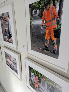 Vier Bilder der Ausstellung in weißen Rahmen an einer Wand