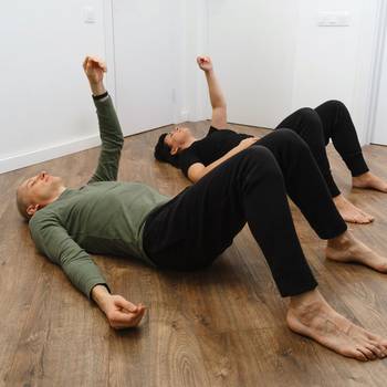 Faszientraining am Boden © ninelutsk - stock.adobe.com Zwei Menschen üben Faszientraining in Sportkleidung und heben einen Arm