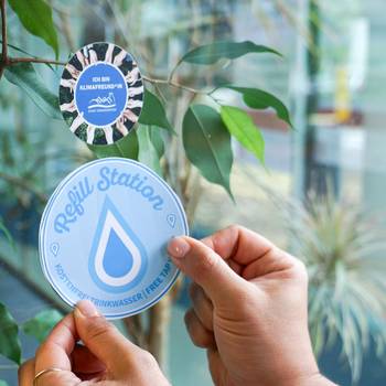 Aufkleber wird an Fenster geklebt