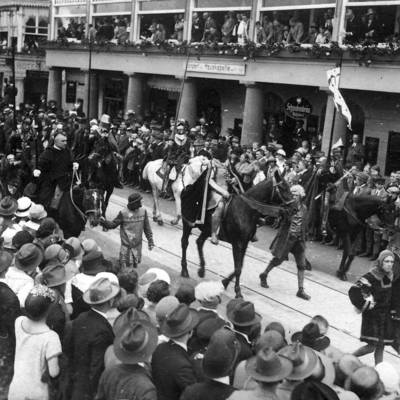 schwarz-Weiß-Foto eines Festzuges mit Pferden