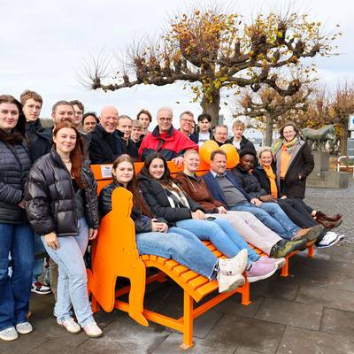 Auf und hinter der Bank stehen und sitzen u.a. Vertreter sowie Schülerinnen und Schüler der Schule, Bürgermeister Lutz Wagner, das Gleichstellungsteam.