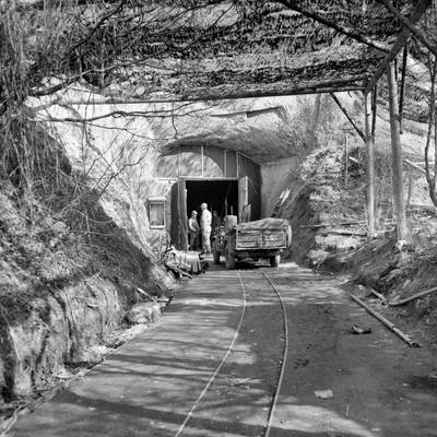 Mit einem Tarnnetz überspannter Eingang der sogenannten Aero-Stahl-Grube im März 1945 bei der Begutachtung durch US-Truppen.