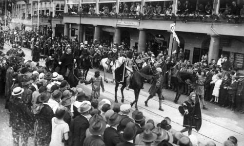 schwarz-Weiß-Foto eines Festzuges mit Pferden