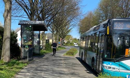 Weg zur Bushaltestelle, Bild mit Wartehäuschen und Bus