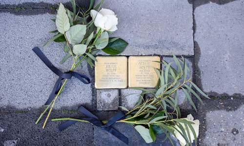 Zwei Stolpersteine mit weißen Rosen