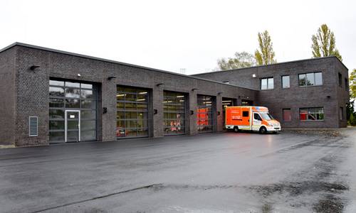 Die neue Rettungswache in Königswinter-Oberpleis ist in Betrieb genommen worden. Ein Rettungswagen steht vor dem Gebäude.