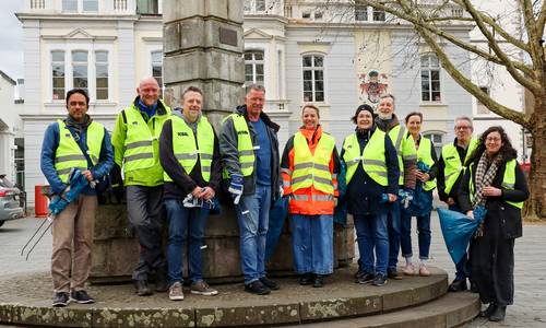 Das Team der Stadtverwaltung in Warnwestern und mit Zangen und Müllbeuteln vor dem Rathaus