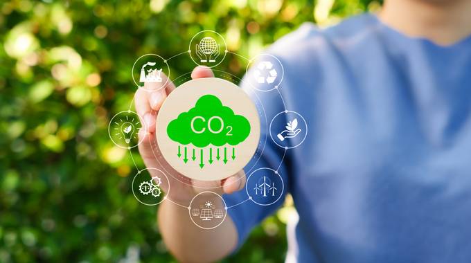 Eine Hand deutet auf eine Wolke mit einem CO2-Symbol