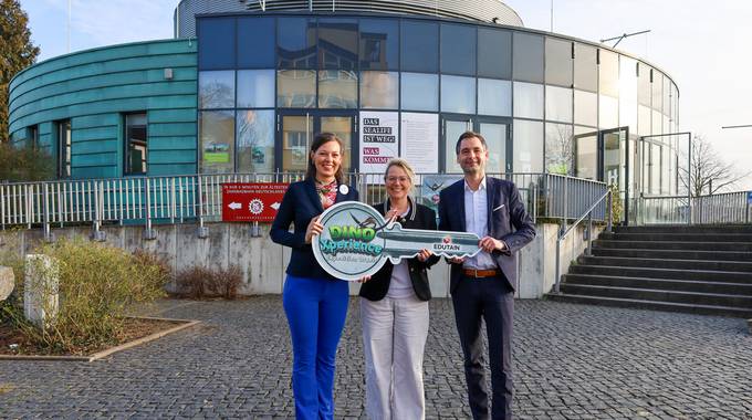 Janine Jaensch (li.), CEO der EDUTAIN AG, übernahm den symbolischen Schlüssel für die künftige Erlebniswelt DinoXperience – Expedition Urzeit von Bürgermeisterin Heike Jüngling und dem Landtagsabgeordneten Jonathan Grunwald. © Stadt Königswinter/Pressestelle Schlüsselübergabe vor dem Gebäude der neuen Erlebniswelt an der Rheinallee