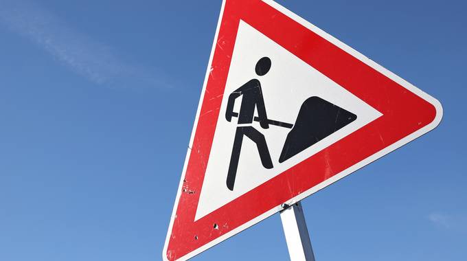 Baustellenschild vor blauem Himmel